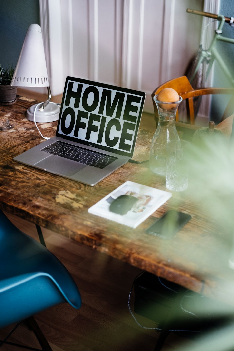 Moderno computer portatile su una scrivania rustica in legno con testo "ufficio domestico".