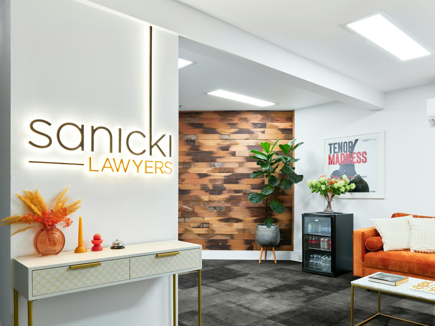 Moderna reception d'ufficio con divano e insegna Sanicki Lawyers.